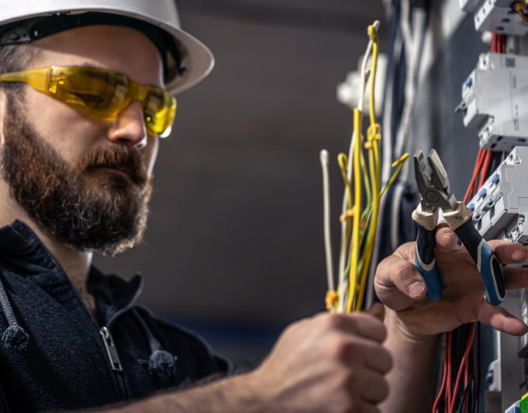 male-electrician-works-switchboard-with-electrical-connecting-cable-1.jpg