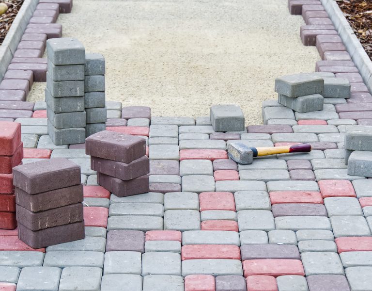 worker-laying-paving-stones-stone-pavement-construction-worker-laying-cobblestone-rocks-sand